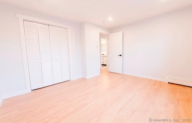 unfurnished bedroom featuring light wood-type flooring and a closet