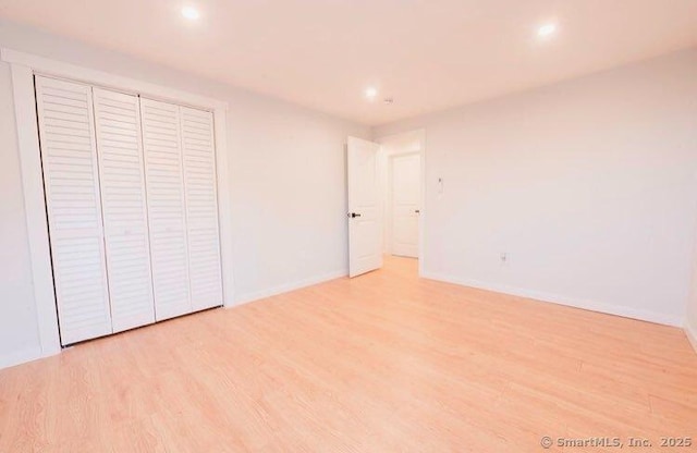 unfurnished bedroom featuring light hardwood / wood-style floors and a closet