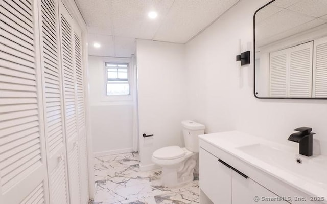 bathroom featuring a paneled ceiling, toilet, and vanity