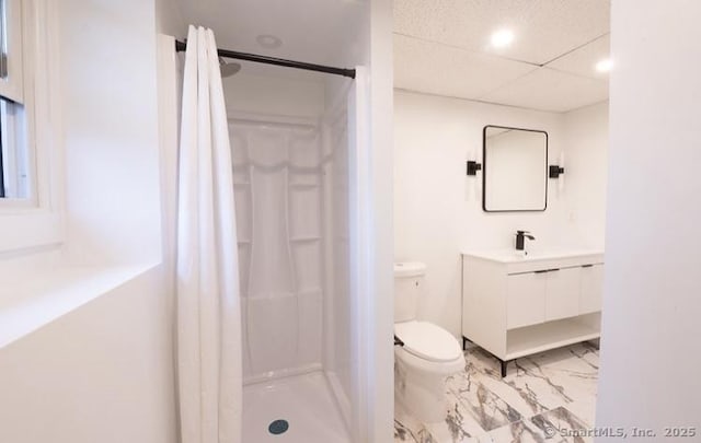 bathroom with vanity, a drop ceiling, a shower with shower curtain, and toilet