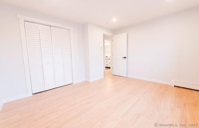 unfurnished bedroom with a closet and light hardwood / wood-style flooring