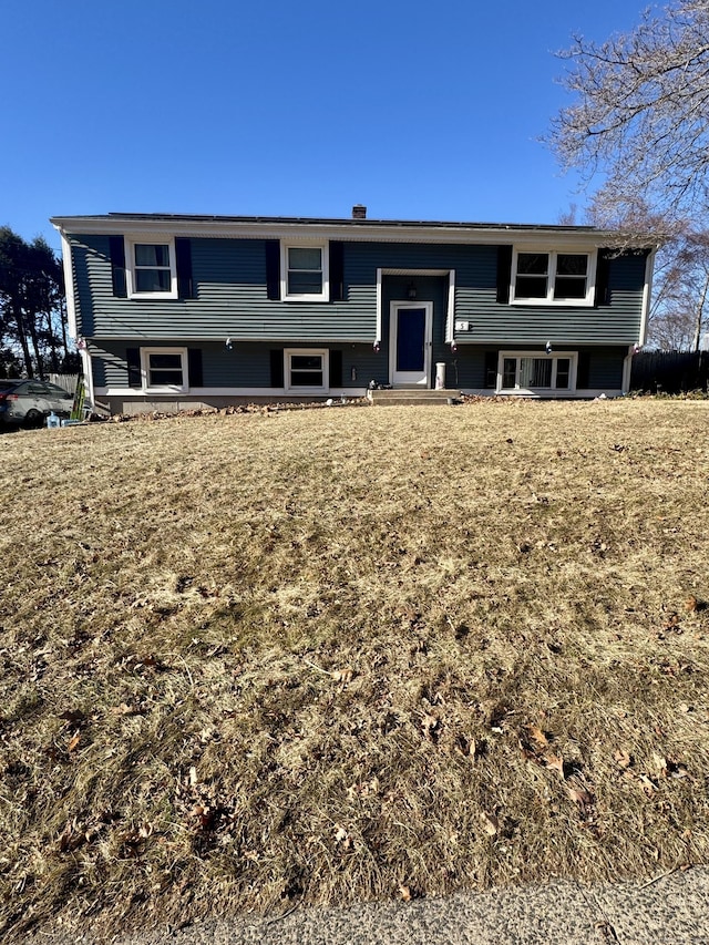 split foyer home with a front lawn