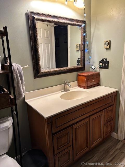 bathroom featuring hardwood / wood-style floors, vanity, and toilet