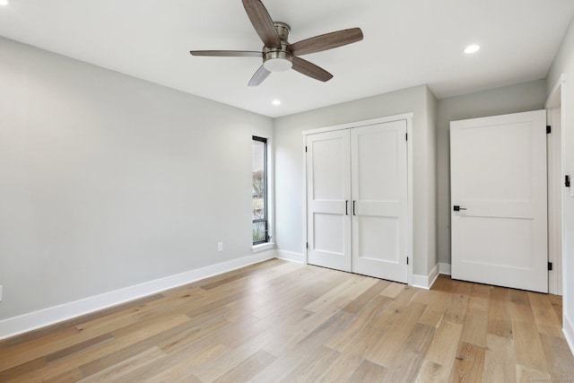 unfurnished bedroom with light hardwood / wood-style flooring, a closet, and ceiling fan