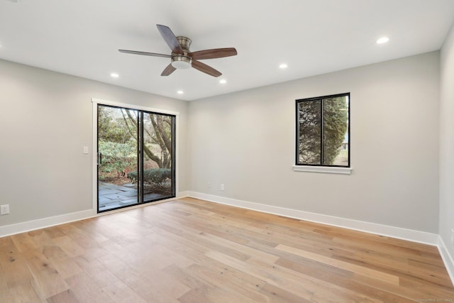 empty room with ceiling fan and light hardwood / wood-style flooring