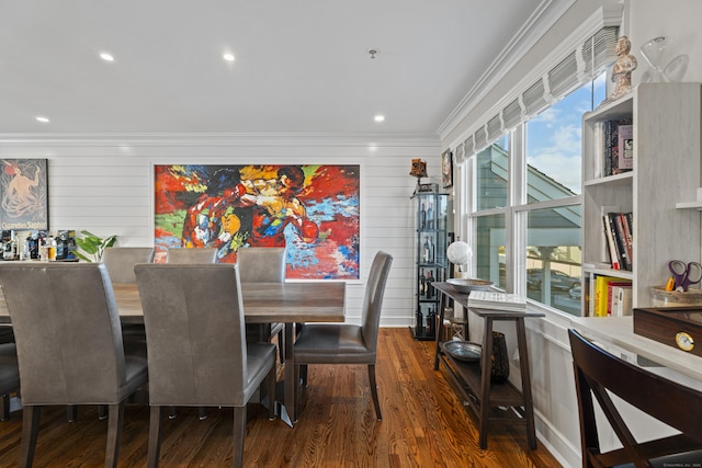 dining room featuring dark hardwood / wood-style floors, wood walls, and ornamental molding