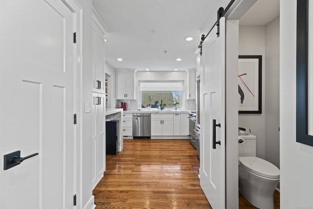 interior space with recessed lighting, toilet, wood finished floors, and vanity