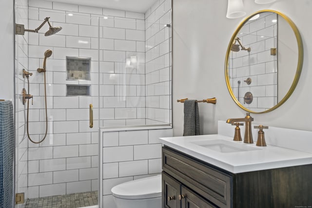 bathroom with a stall shower, toilet, and vanity