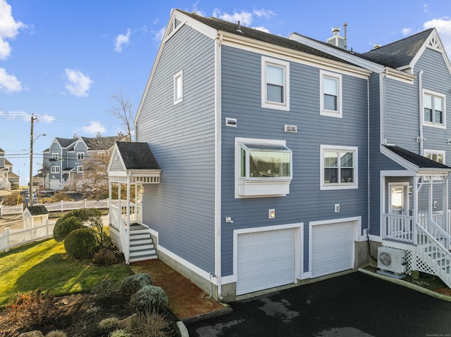 view of side of property featuring ac unit and a garage