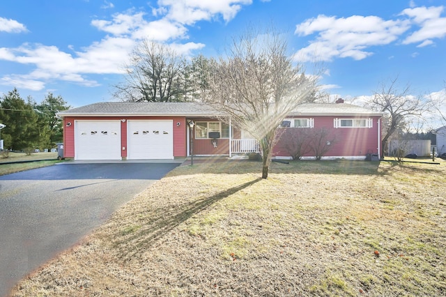 single story home with a porch, a garage, and a front yard