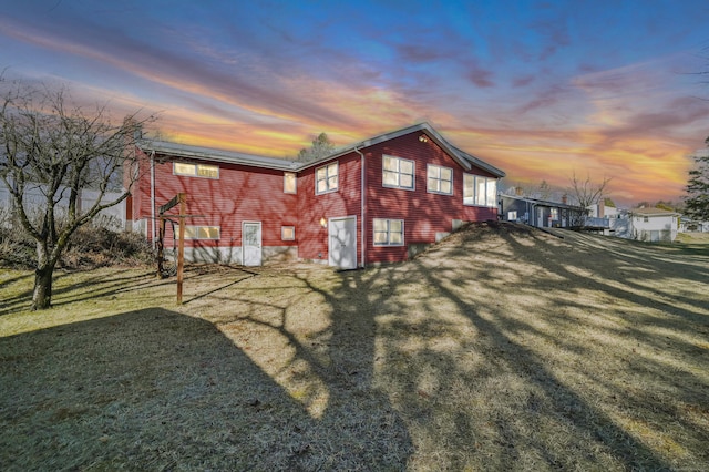 property exterior at dusk featuring a yard