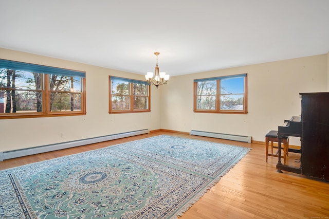 interior space with wood-type flooring, a baseboard heating unit, and a notable chandelier