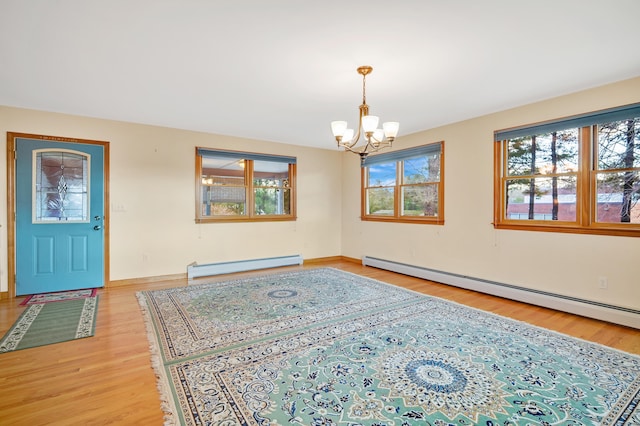 interior space featuring hardwood / wood-style flooring, a chandelier, and a baseboard heating unit