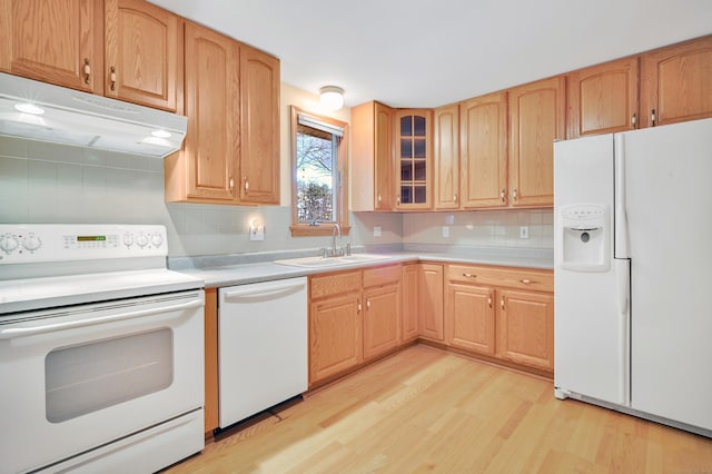 kitchen with decorative backsplash, light wood-type flooring, white appliances, and sink