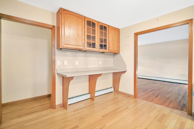 kitchen with backsplash, light hardwood / wood-style floors, and baseboard heating