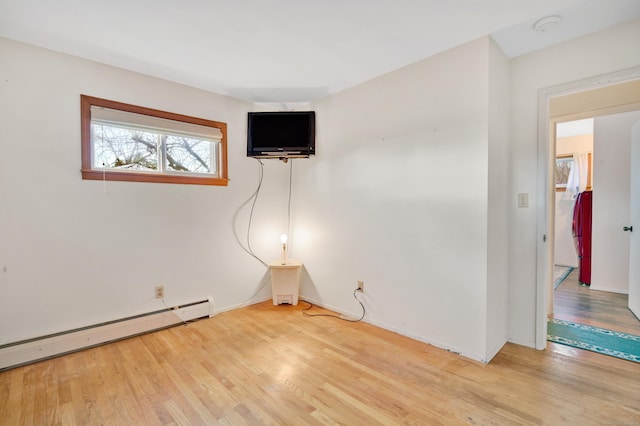 empty room with hardwood / wood-style floors and a baseboard radiator