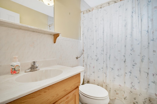 bathroom with walk in shower, vanity, toilet, and tile walls