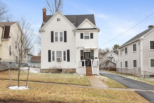 view of front facade featuring a front lawn and cooling unit