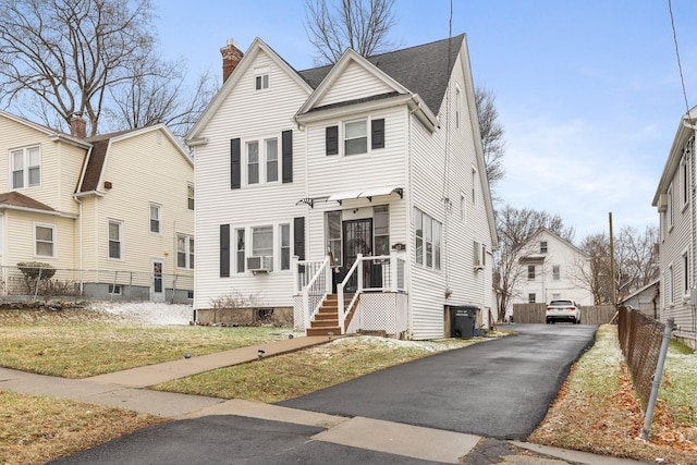 view of property featuring cooling unit and a front yard