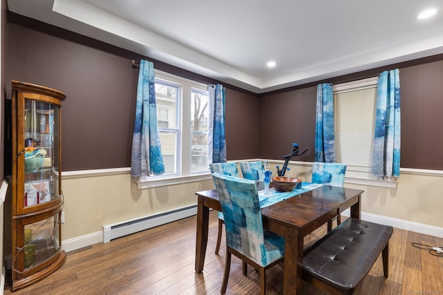 dining space featuring wood-type flooring and a baseboard heating unit