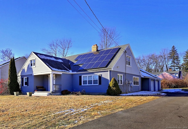 view of front of property featuring solar panels and a garage