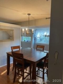 dining area with a notable chandelier and hardwood / wood-style flooring