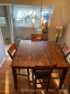 dining area with hardwood / wood-style floors and a notable chandelier