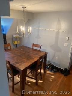 dining room with hardwood / wood-style floors and an inviting chandelier