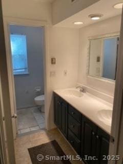 bathroom featuring tile patterned flooring, vanity, and toilet