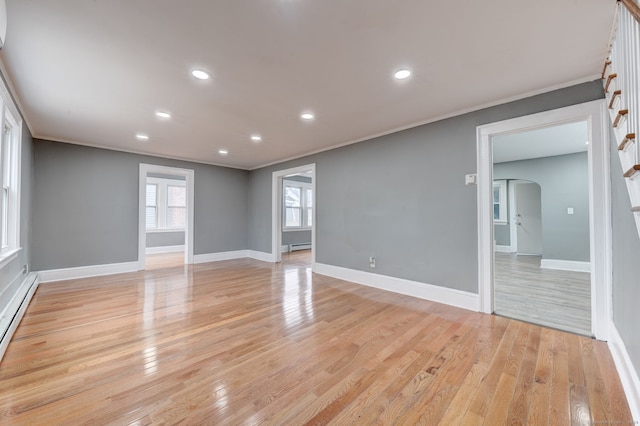 spare room with ornamental molding, light hardwood / wood-style flooring, and a baseboard heating unit