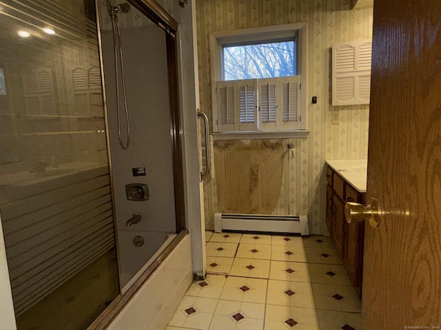 bathroom featuring baseboard heating, vanity, and combined bath / shower with glass door