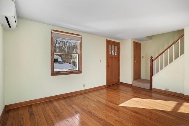 entrance foyer featuring a wall mounted air conditioner and wood-type flooring