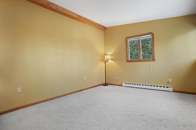 spare room with carpet floors and a baseboard heating unit