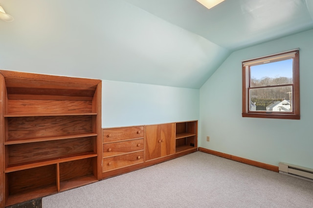 additional living space with baseboard heating, light carpet, and vaulted ceiling