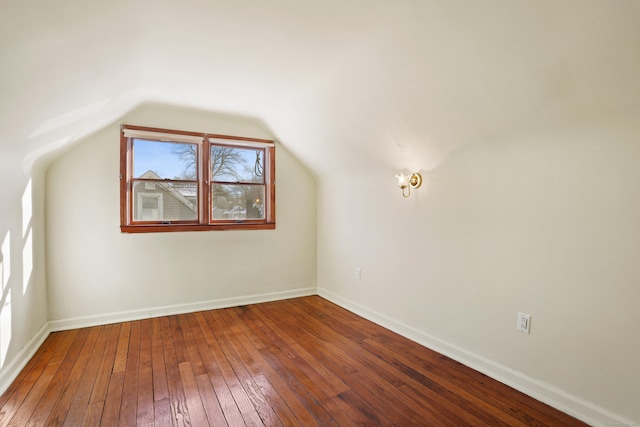 bonus room with hardwood / wood-style floors and vaulted ceiling