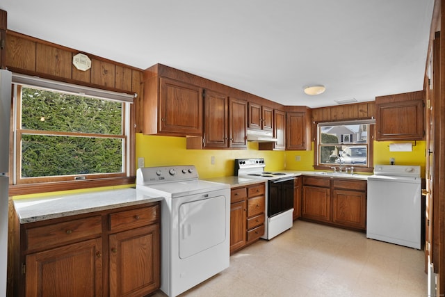 kitchen featuring washer / clothes dryer, electric range, sink, and light stone countertops