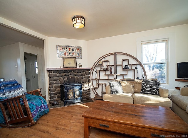 living room with a wood stove and hardwood / wood-style floors