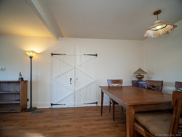 dining area featuring beam ceiling and hardwood / wood-style flooring