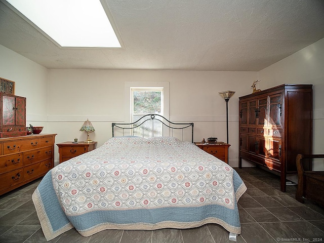 bedroom featuring a skylight and a textured ceiling