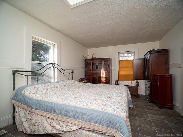 bedroom featuring multiple windows and a textured ceiling