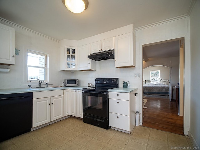 kitchen featuring black appliances, white cabinets, sink, and a wealth of natural light