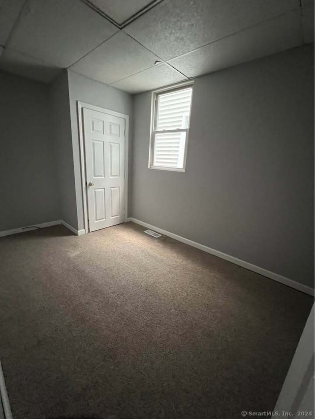 interior space featuring a drop ceiling and carpet