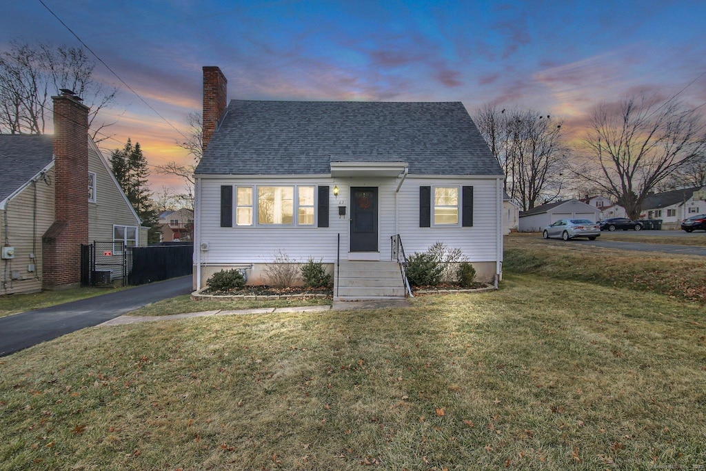 bungalow-style home with a yard and central AC