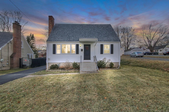 bungalow-style home with a yard and central AC