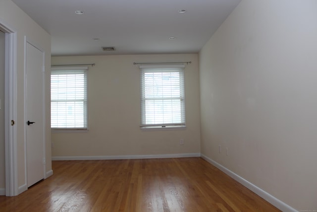 unfurnished room with light wood-type flooring and a wealth of natural light