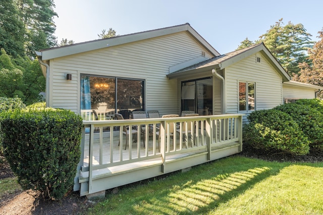 rear view of property featuring a yard and a deck