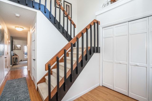 stairs featuring wood-type flooring and a textured ceiling