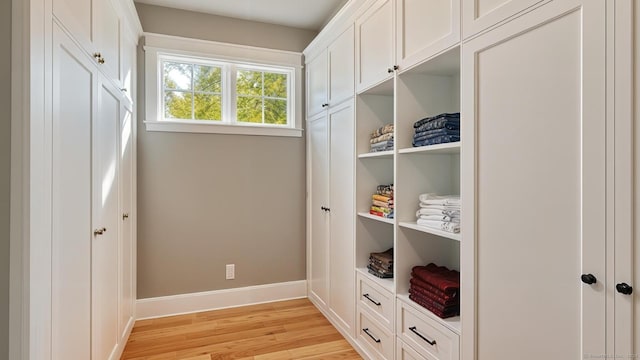 mudroom featuring built in shelves and light hardwood / wood-style flooring