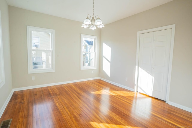 interior space featuring hardwood / wood-style floors, plenty of natural light, and a notable chandelier