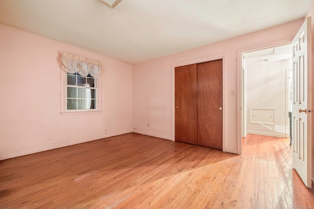 unfurnished bedroom with light hardwood / wood-style floors and a closet